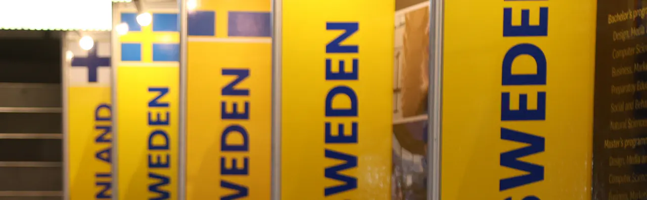 Spanduk kuning bertuliskan SWEDEN dan FINLAND yang berjajar di booth pameran.